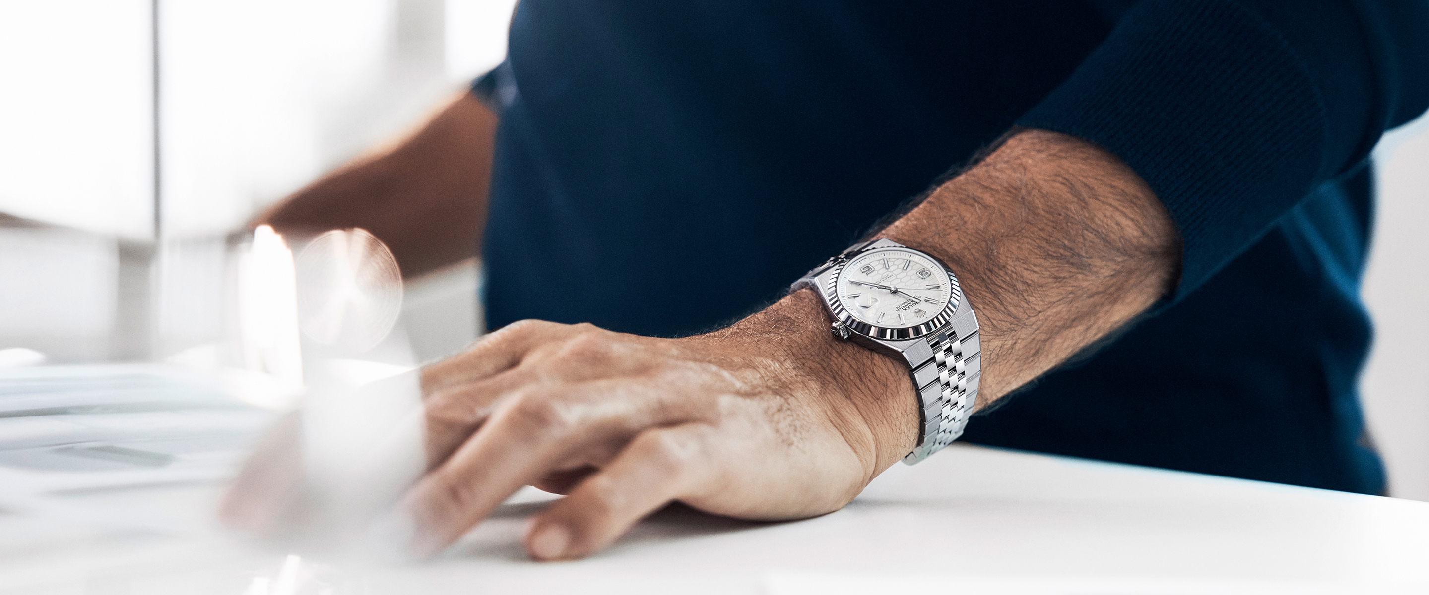 Die Rolex Land-Dweller mit tiefweißem Zifferblatt mit Wabenmuster getragen am Handgelenk